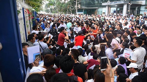 Thousands of people line up at the South korean Embassy in Hanoi to apply for visas