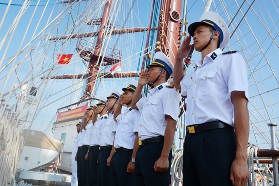 Crew members of the Le Quy Don sailing ship make salute when the ship reaches Changi port. (Photo: qdnd.vn)
