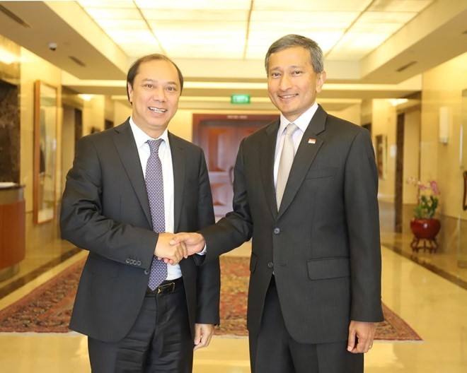 Vietnamese Deputy Foreign Minister Nguyen Quoc Dung (L) is welcomed by Singaporean Foreign Minister Vivian Balakrishnan in the island city state (Photo: VNA)
