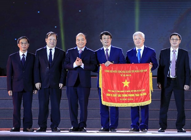 Prime Minister Nguyen Xuan Phuc (third from left) presents the Government’s Emulation Flag to the Vietnam National Cement Corporation. 