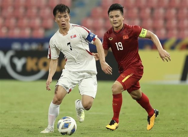 Team captains of Vietnam Nguyen Quang Hai (in red) and the DPRK Ri Chung-gyu vie for the ball (Photo: VNA)