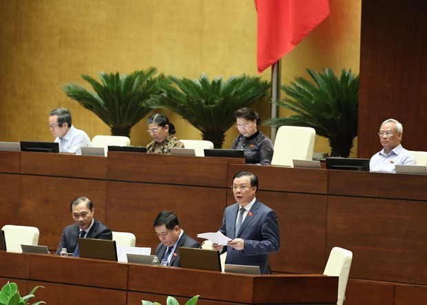 Minister of Finance Dinh Tien Dung (standing) speaks at the plenary sitting on June 15 (Photo: VNA)