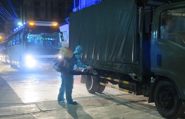 A worker sprays disinfectant on a vehicle entering a concentrated quarantine facility (Photo: VNA)