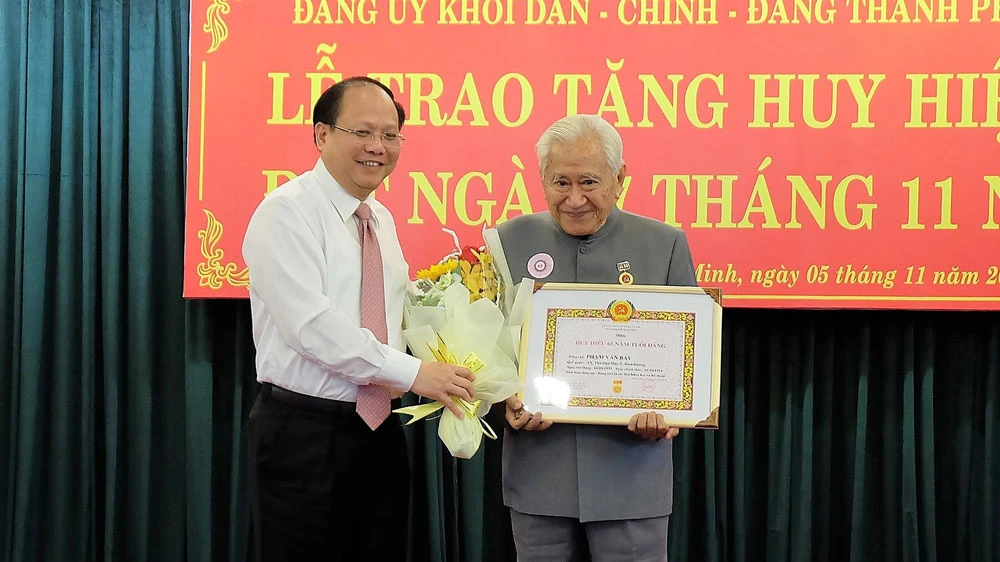 Đồng chí Tất Thành Cang trao Huy hiệu 65 năm tuổi Đảng cho đồng chí Phạm Văn Bảy