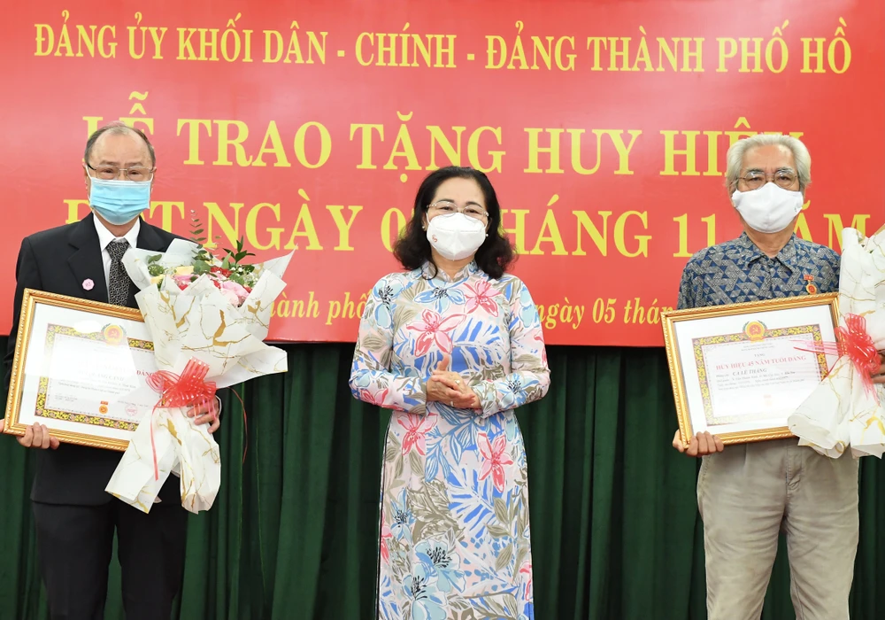 Chủ tịch HĐND TPHCM Nguyễn Thị Lệ trao Huy hiệu 45 năm tuổi Đảng cho đồng chí Ca Lê Thắng và đồng chí Bùi Quang Cảnh. Ảnh: VIỆT DŨNG