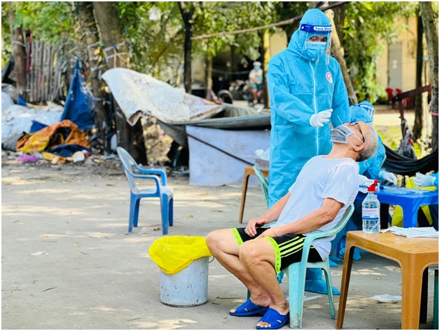 Nhân viên y tế lấy mẫu xét nghiệm nhanh cho người dân trong khu vực có ổ dịch cộng đồng tại huyện Hóc Môn