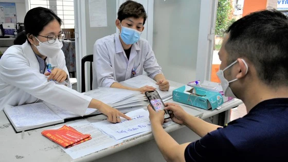 Bác sĩ thực tập Nguyễn Thị Quỳnh Trang khám, tư vấn cho người dân tại Trạm y tế phường Hiệp Thành, quận 12