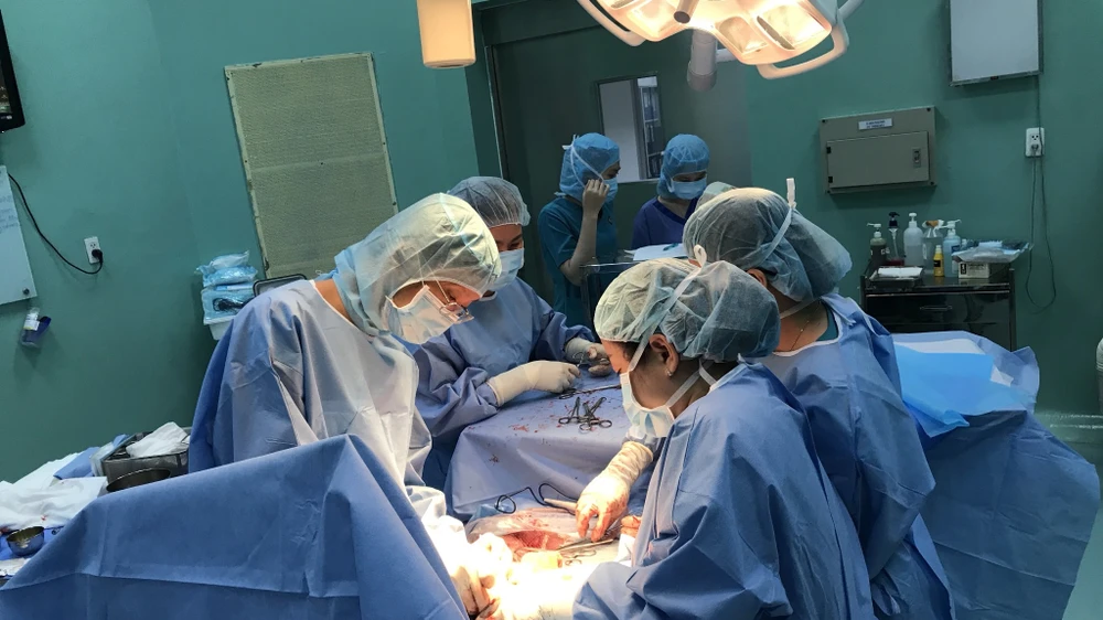 Các bác sĩ Bệnh viện Hùng Vương và Bệnh viện Tim Tâm Đức đang thực hiện ca phẫu thuật bắt con cho sản phụ