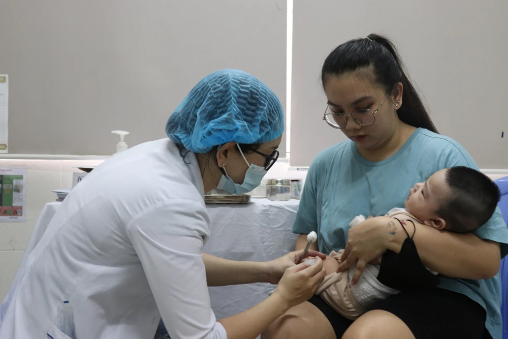 Nhân viên Trạm Y tế phường Phú Mỹ (quận 7) đang tiêm vaccine cho trẻ
