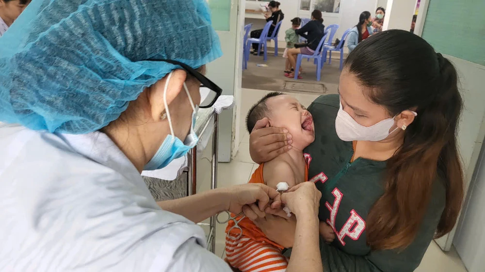 Nhân viên Trung tâm Y tế quận Tân Bình đang tiêm vaccine tiêm chủng mở rộng cho trẻ