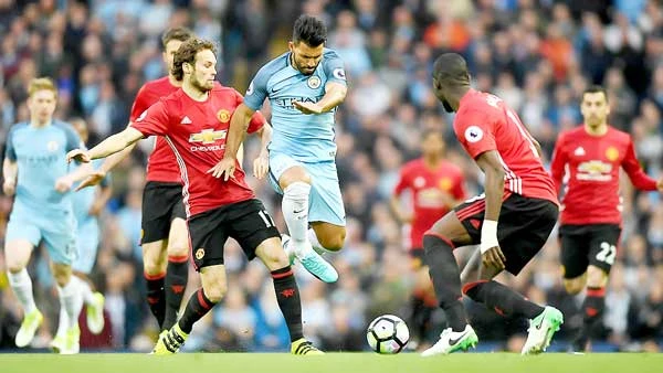 Aguero (giữa) bất lực trước hàng thủ Man.United trong trận derby Manchester