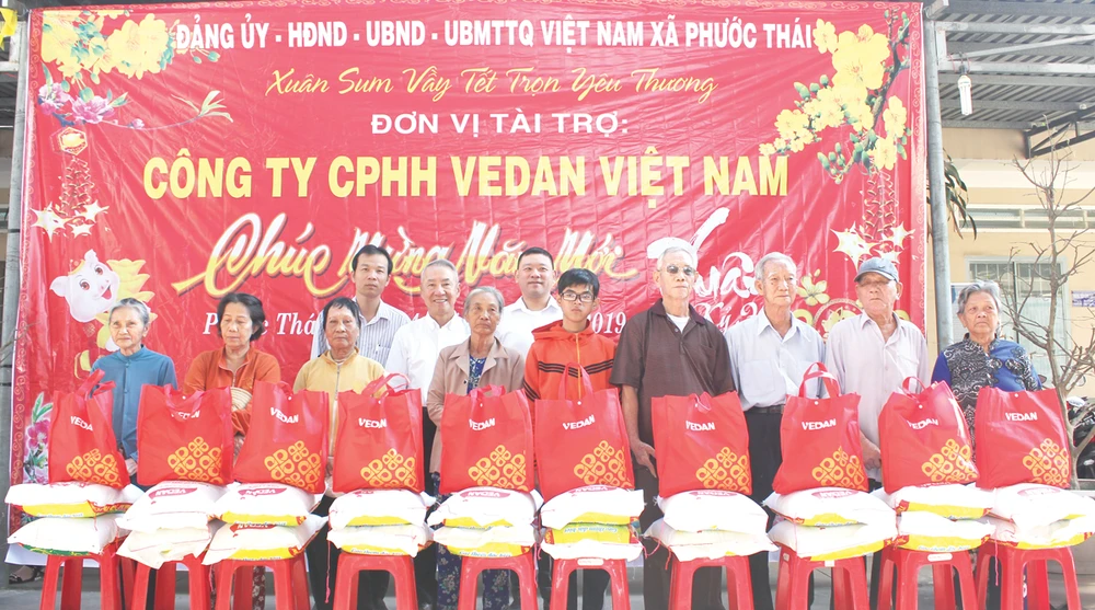 Ông Hsieh Jau Hwang - Trưởng sách lược Vedan Việt Nam (người đứng thứ 2 từ trái qua) trao quà tết cho bà con xã Phước Thái, huyện Long Thành