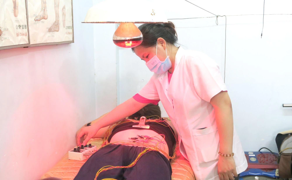 Bác sĩ của Trạm Y tế phường Tân Quý (quận Tân Phú) thăm khám cho người bệnh