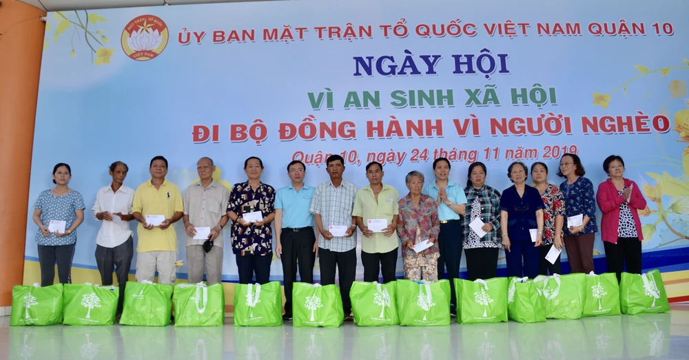 Đồng chí Huỳnh Thị Xuân Lam và Bí thư Quận ủy quận 10 trao quà cho các gia đình chính sách có hoàn cảnh khó khăn
