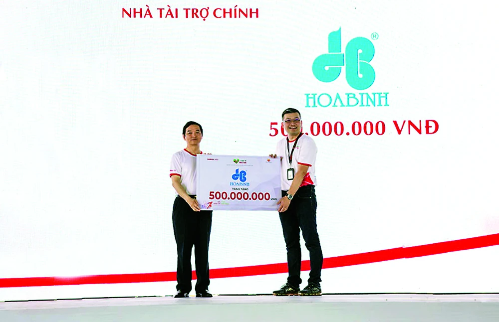 Ông Lê Viết Hải, CT. HĐQT kiêm TGĐ Hòa Bình (trái) trao tặng 500 triệu đồng cho chương trình