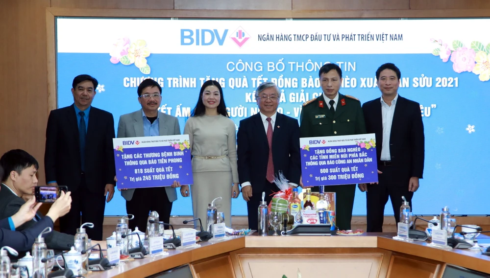 Đại diện BIDV trao bảng tượng trưng cho các đơn vị để tặng quà Tết cho người nghèo 