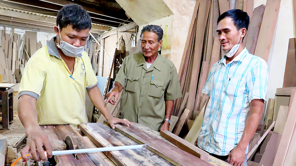 Xưởng gỗ của ông Tạ Ngọc Quang (đứng giữa) tạo công ăn việc làm cho nhiều con em thương bệnh binh 