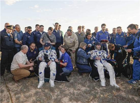 法國宇航員托馬斯·佩斯凱（前右三）和俄羅斯宇航員奧列格·諾維茨基（前左三）安全著陸後坐在椅子上。（圖源：互聯網）