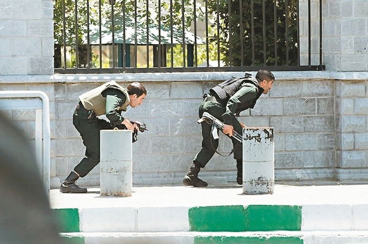 伊朗議會大樓7日遭攻擊時，安全部隊尋找掩護準備攻堅。（圖源：路透社）