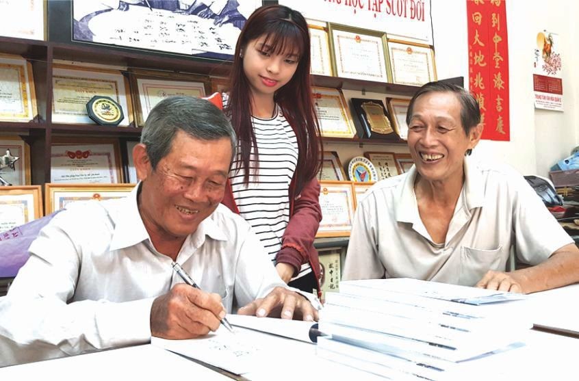 劉為安先生(左一)正在簽名贈書給文友。