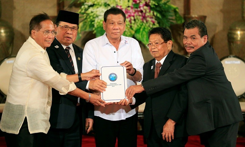 菲律賓最大叛軍組織“摩伊解”的代表和政府官員到馬尼拉總統府，將“邦薩摩洛基本法”新草案呈給總統杜特爾特（中）。（圖源：路透社）