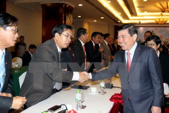 市人委會主席阮成鋒與老撾中部3省代表們握手打交道。（圖源：越通社）