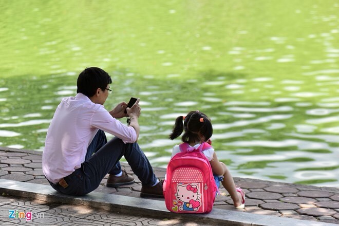 父親專注上網，讓女兒“孤單”地坐在一旁。(示意圖源：互聯網)