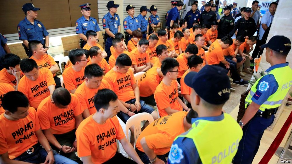 菲律賓全國警察總長羅薩（右）週四和43名穿著橙色上衣的嫌犯，一起出席記者會。(圖源：路透社)