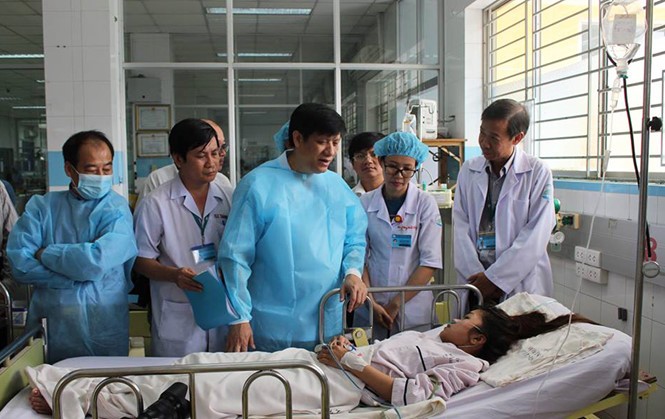 衛生部副部長阮清隆(中)在市衛生廳領導的陪同下到市熱帶病醫院探望登革熱患者。（圖源：元媚）
