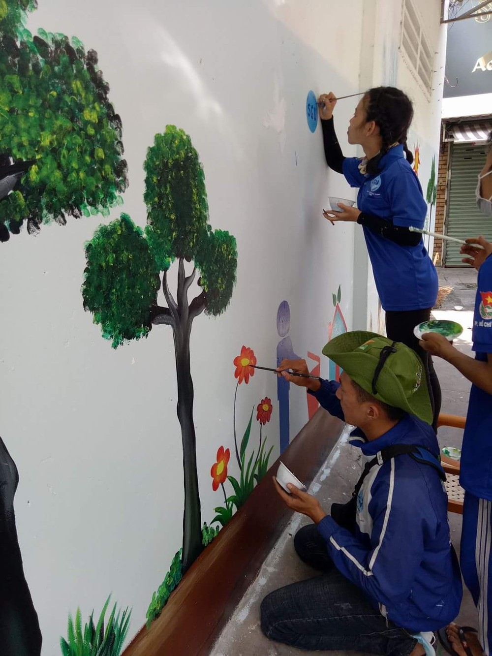 志願青年在巷子的牆壁繪上關注環保的圖畫。（圖源：心雨）