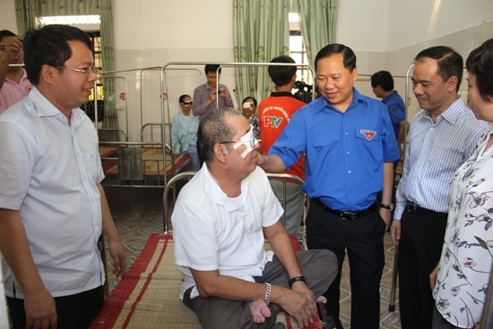 越南中央青聯會主席阮飛隆(藍衣)對動手術後的病人表示慰問。（圖源：共青團中央官方網站）