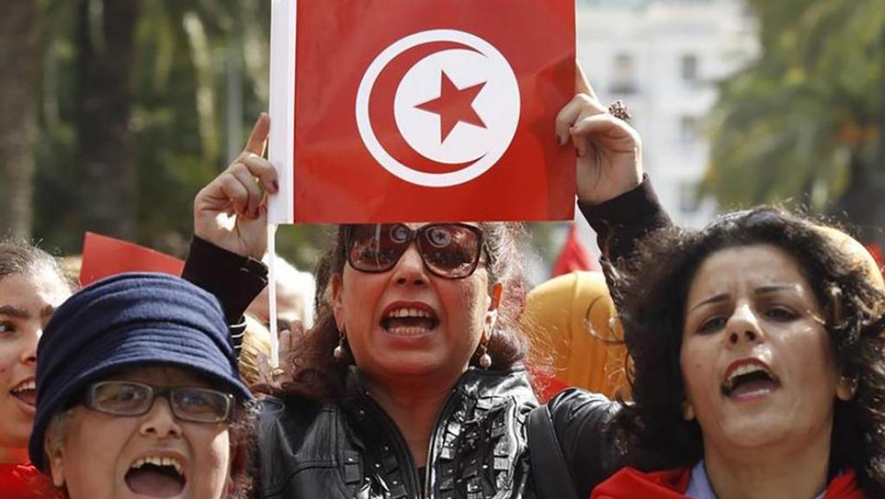 一名突尼斯婦女手持該國國旗進行慶祝。（圖源：互聯網）