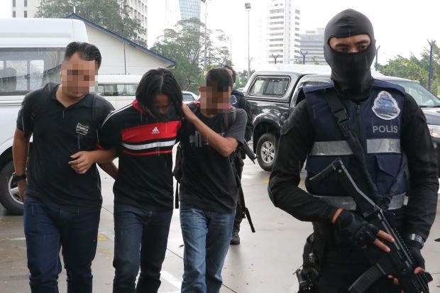 圖為馬來西亞警方逮捕的一名涉嫌極端組織嫌犯（左二）。(圖源：互聯網）