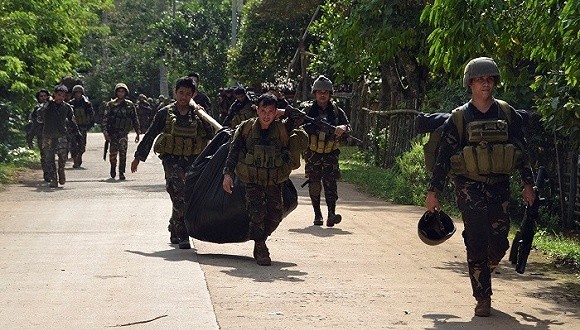 菲律賓政府軍與阿布沙耶夫武裝在菲南部蘇祿省交火，士兵搬運武裝分子遺體。（圖源：互聯網）