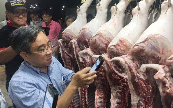 市工商廳領導於7月31日在集散市場進行掃描豬肉的溯源碼。（圖源：青海）