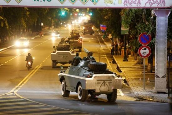一隊柬埔寨軍車8月11日夜間駛過金邊的一條街道（圖源：路透社）。