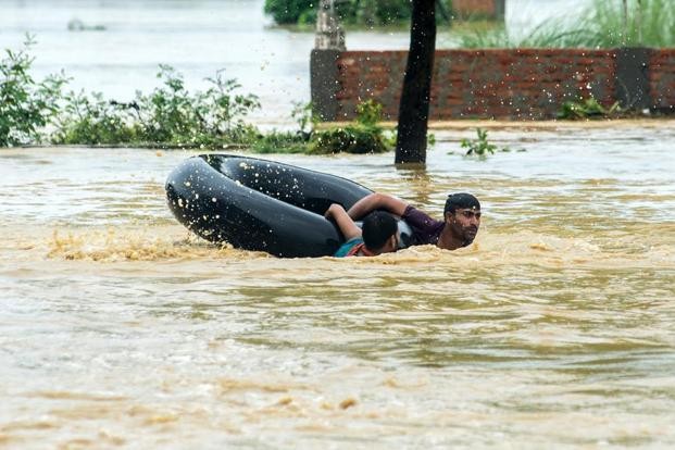 圖為8月13日，尼泊爾比爾根傑帕薩區民眾在洪水中。(圖源：AFP)