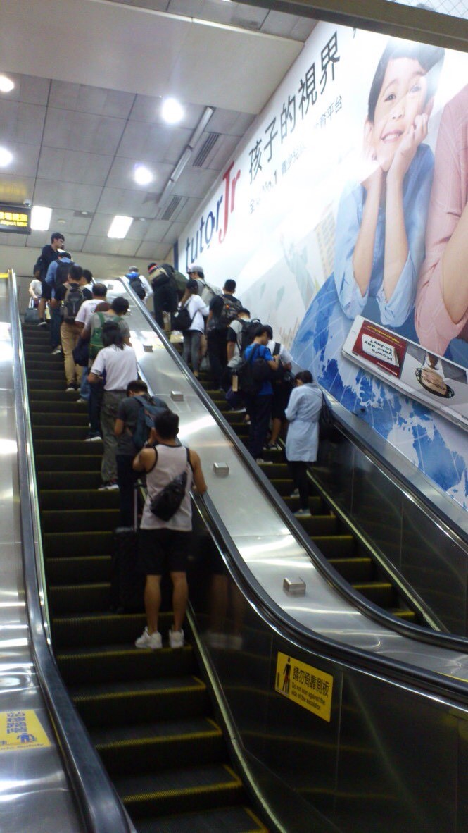 乘客在台北地鐵乘自動扶梯。