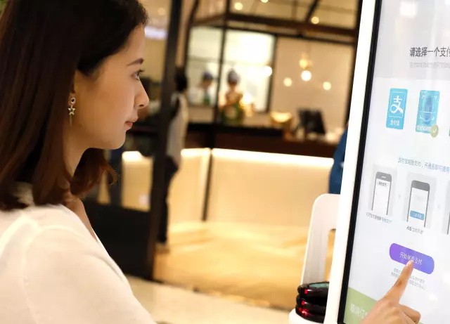 客戶刷刷臉在自助點餐機上選餐。