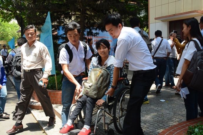 殘疾大學生潘氏金雲獲同學輔助搭乘巴士。