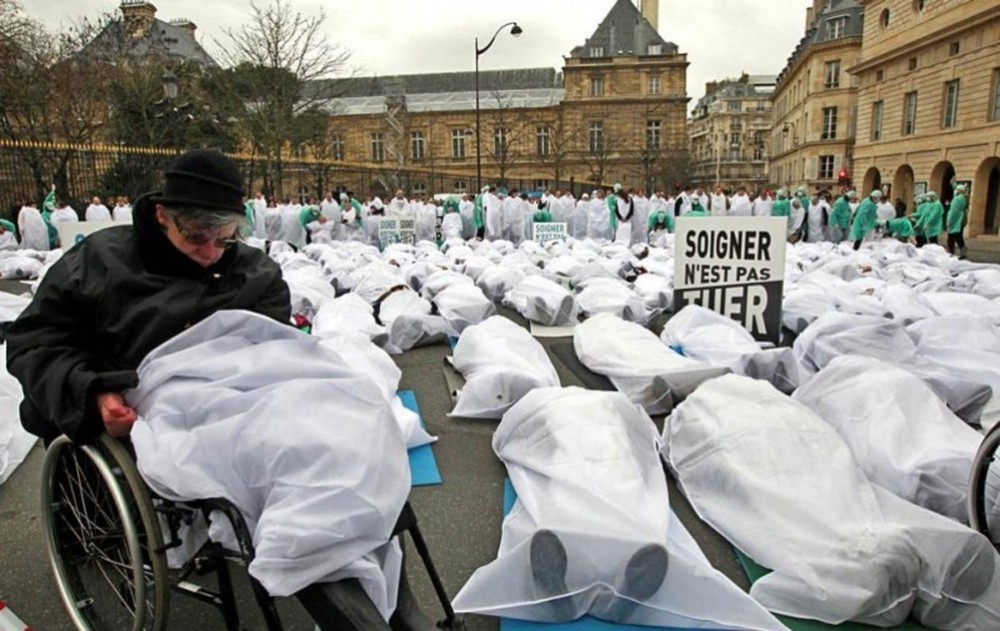 人類生存聯盟成員罩著白布躺在大街上抗議安樂死合法化法案。（圖源：互聯網）