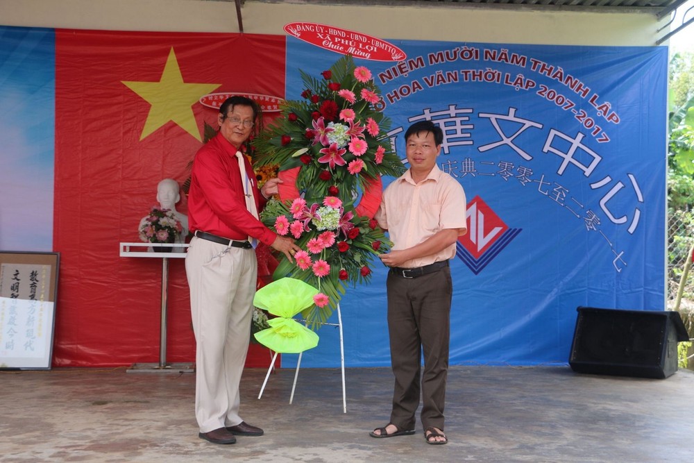 富利鄉黨委書記、人民議會主席范忠孝向李國維主任（左）贈送鮮花祝賀校慶。