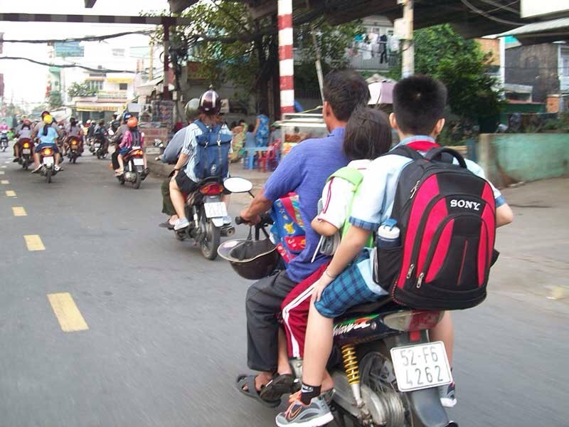 像這般既超載而自己及孩子都沒戴上安全帽的情景，在街上是司空見慣的。