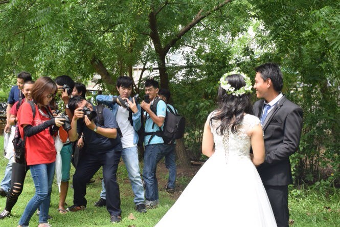 “免費婚照攝影”俱樂部成員們正為一對工人夫妻拍婚紗照。