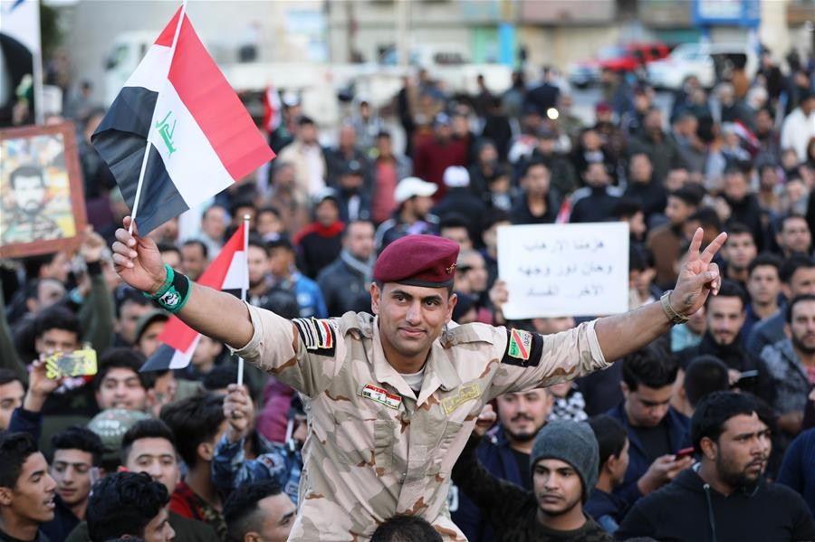 12月10日，在伊拉克巴格達解放廣場，人們集會慶祝擊敗“伊斯蘭國”。伊拉克總理阿巴迪9日宣布，政府軍已收復極端組織“伊斯蘭國”在伊控制的所有領土，伊拉克取得打擊“伊斯蘭國”的歷史性勝利。（圖源：Khalil Dawood /新華社）