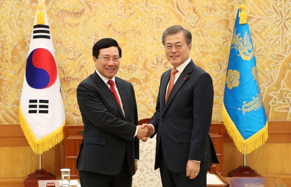 政府副總理、外長范平明（左）與韓國總統文在寅握手合影。（圖源：韓聯社）