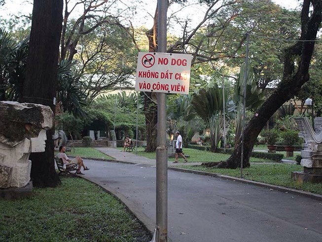 公園周圍當眼處掛上禁止帶狗入公園規定的告示牌，牌上內容用越文及英文書寫，並有插圖說明。