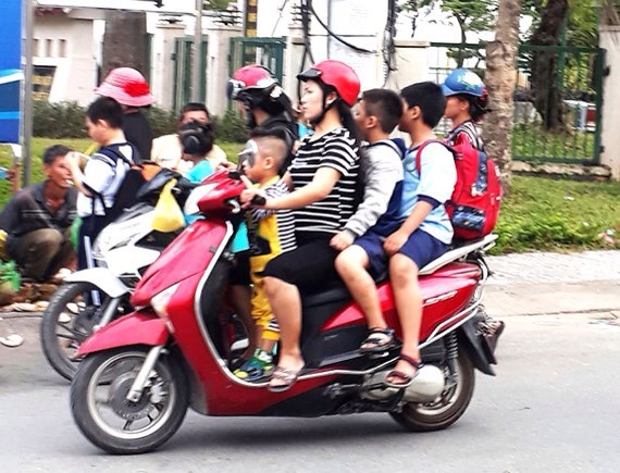 不少家長尚未注重讓孩子坐在摩托車上要戴安全帽。