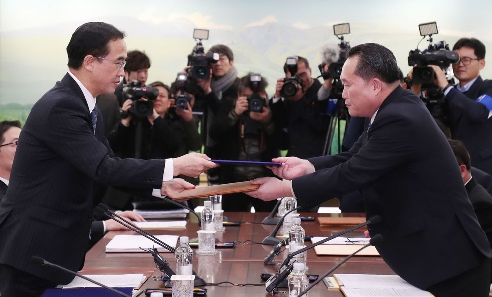 韓方首席代表趙明均（左）和朝方首席代表李善權交換聯合新聞稿。（圖源：AFP）