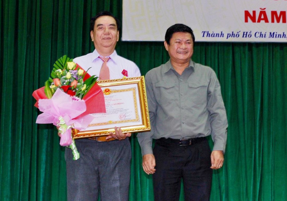 市人委會副主席黃革命(右)向朱杞文同志頒贈三等勞動勳章。